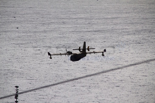 Il Canadair raccoglie acqua in mare davanti a Bussana