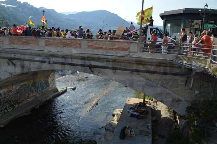 Un'immagine simbolo della manifestazione di oggi: il corteo e sotto i giacigli dei migranti sul Roya