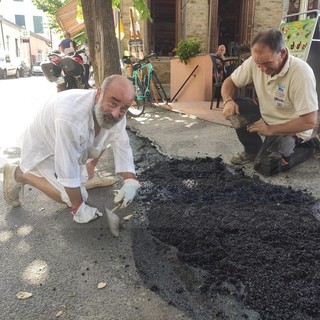 Perinaldo: il gradino crea problemi a una mamma con carrozzina, il Sindaco si mette al lavoro con l'operaio comunale (Foto)