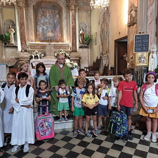 Sanremo: il parroco di San Giacomo Don Antonio benedice gli zainetti dei bambini e dei ragazzi
