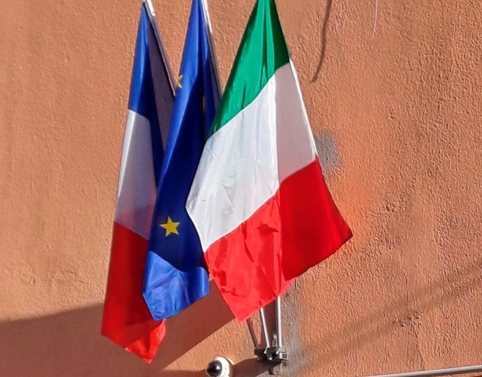 Convenzione Ventimiglia-Mentone: bandiere italiana, francese ed europea spuntano sulla facciata della scuola