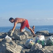 Sanremo, esempio di civiltà: turista torinese ripulisce gli scogli della spiaggia Oasis